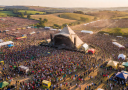 Glastonbury festival aerial view with massive crowd and iconic Pyramid Stage